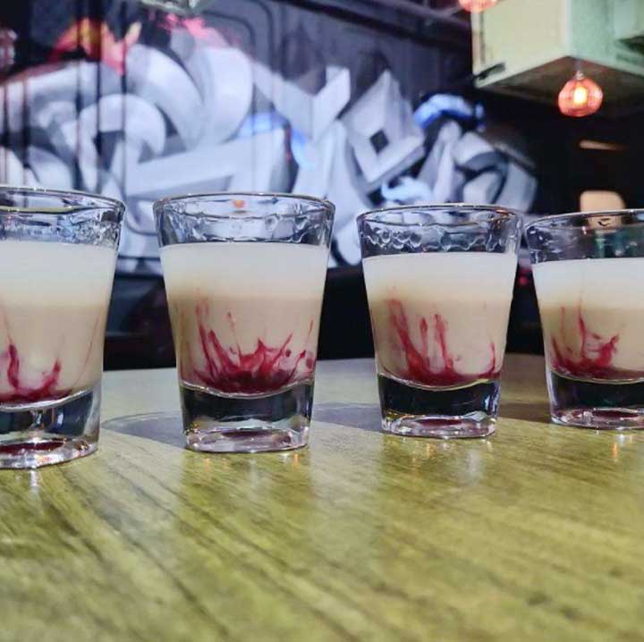 shots pic at bar area with a graffit background done by wicked broz artist for blacklisted lounge