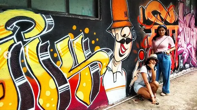 girls posing at graffiti wall art designed by wicked broz artistbombway 4