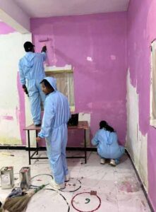 Eicher trucks and buses employees doing base painting for wall art workshop at Anganwadi Kendra 1 at Baggad, Dhar