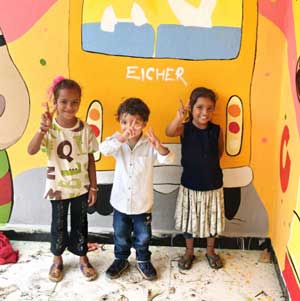 Toddlers in front of a school wall art workshop